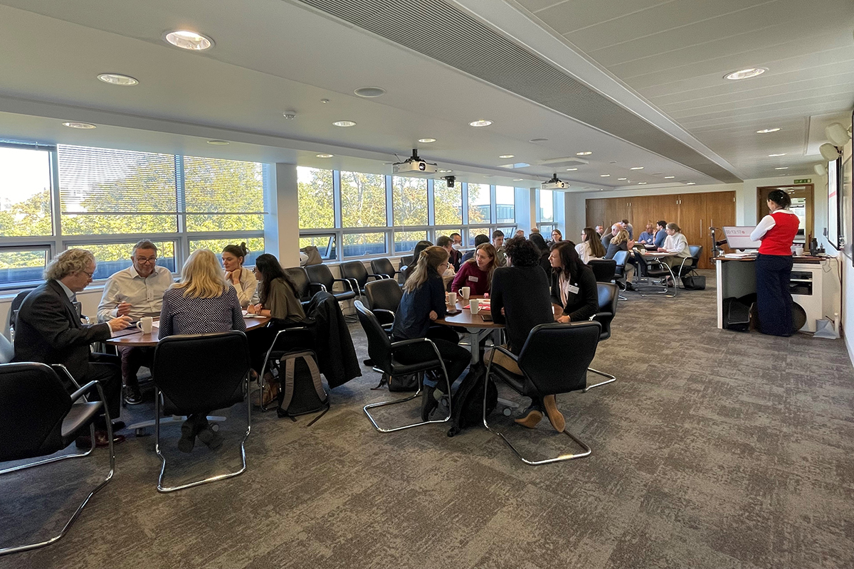 Several groups of people sitting round tables talking