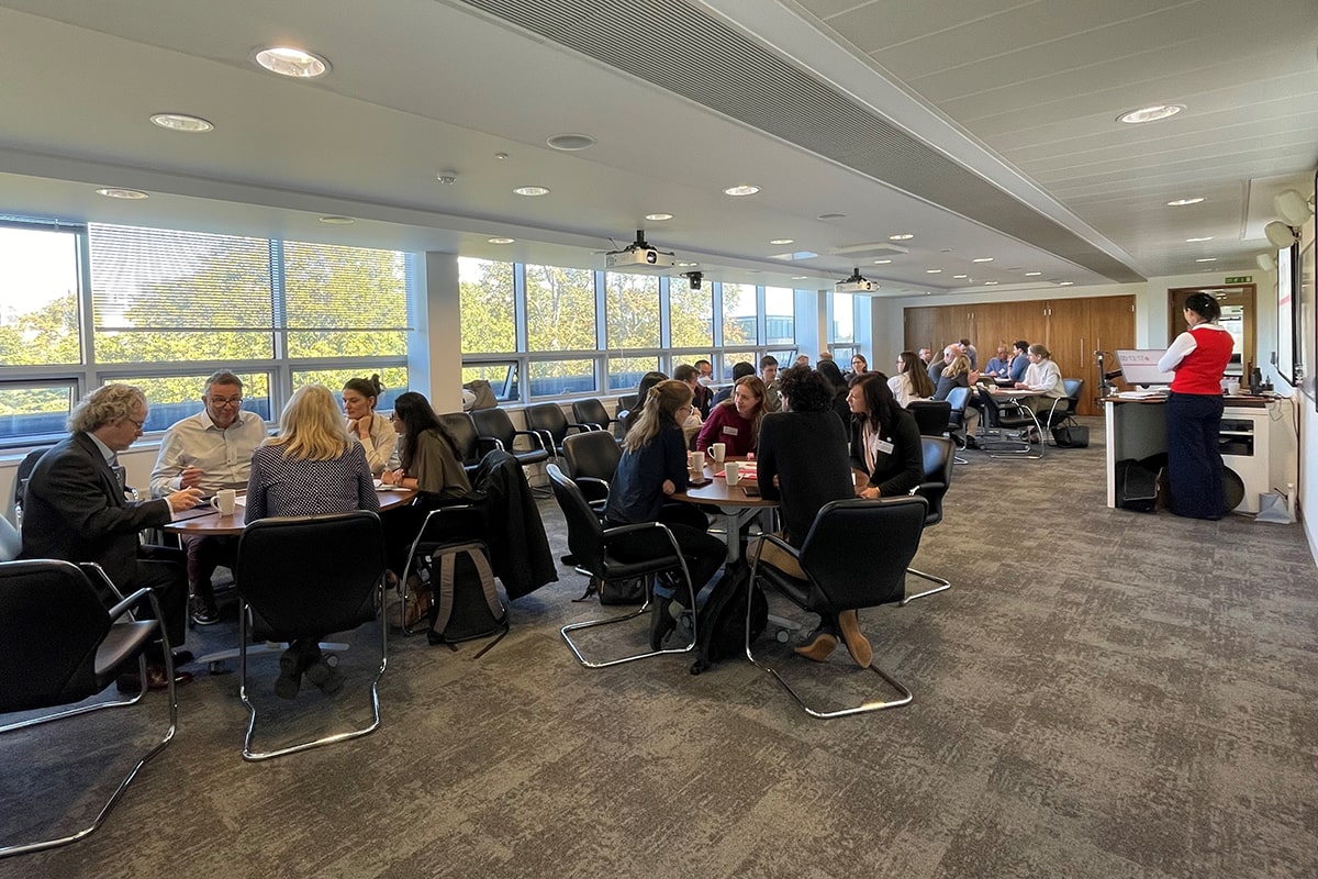 Several groups of people sitting round tables talking