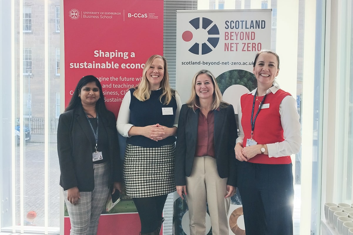 Karishma Ansaram, Kate Symons, Maria Chiara Iannino and Elspeth Wray, standing together in front of pop-up banners