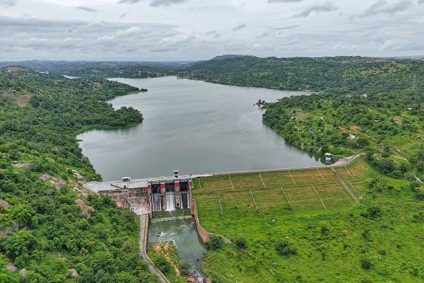 Aerial shot of a large reservoir and dam surrounded by trees and fields