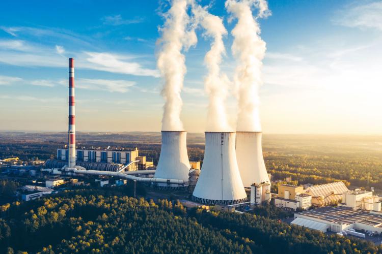 A large factory with smoke coming from the chimneys