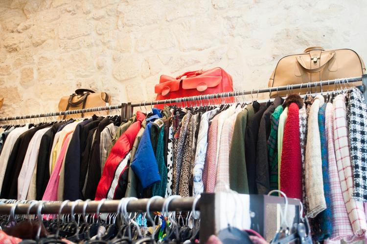A display of handbags and coats in a charity shop