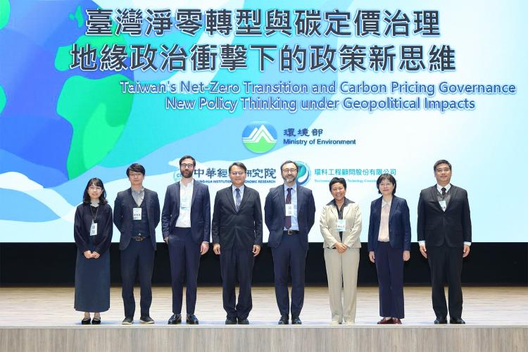 8 participants standing along the stage in front of a sign for Taiwan’s net zero transition and carbon pricing governance conference