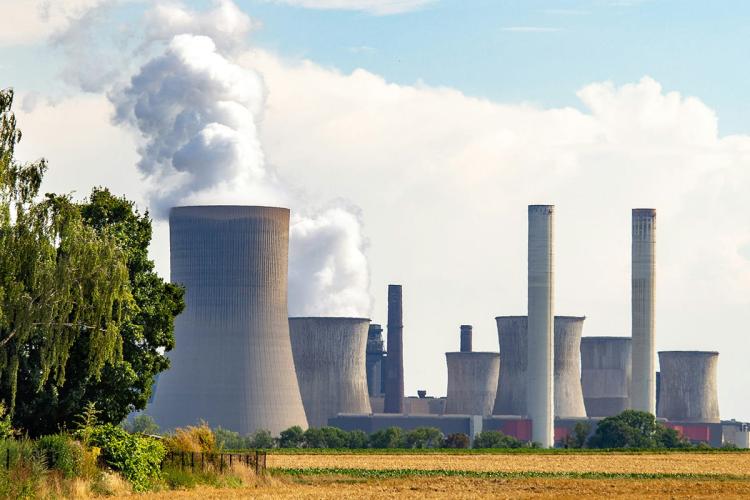 Large power station with chimneys and smoke